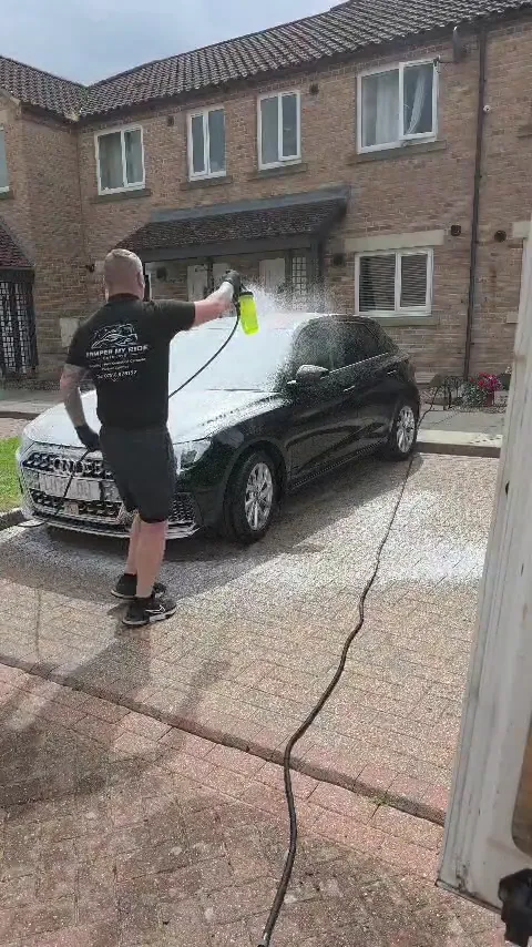 Rinsing a foamed Audi A1 on the driveway